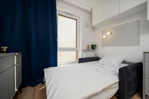 1 dormitorio con 1 cama con cortina azul en Platon Modern Studio, en Łódź