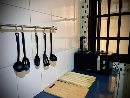a kitchen with utensils hanging on a wall at Charly Agla-Piscine in Cotonou
