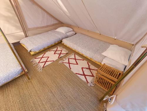 une chambre avec deux lits dans une tente dans l'établissement Du cote de Roussay, à Roussay