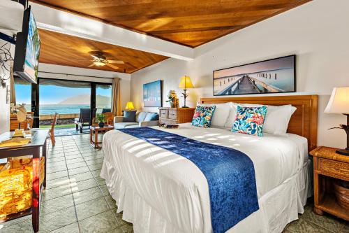 a bedroom with a bed and a view of the ocean at Pohailani 112 in Kahana