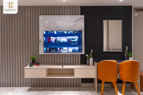 a living room with a tv and two chairs at Homztality Elbatal Mohandeseen in Cairo