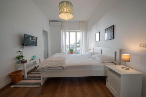 een witte slaapkamer met een groot bed en een raam bij Seconda Stella a Destra in Napels