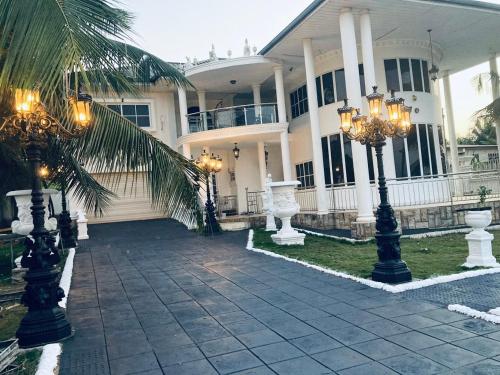a large white house with a palm tree in front of it at The Peacock Mansion in Kumasi
