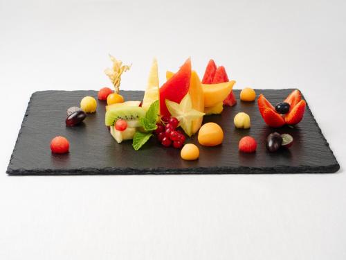 a black plate with fruits and vegetables on it at Albatros Beach Hotel in Letojanni