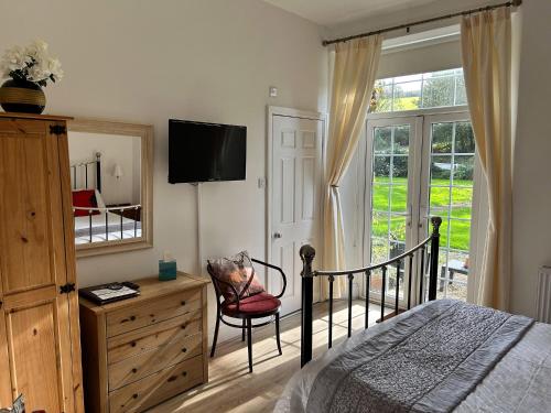 1 dormitorio con cama, tocador y espejo en Exmoor Manor Guest House, en Lynton