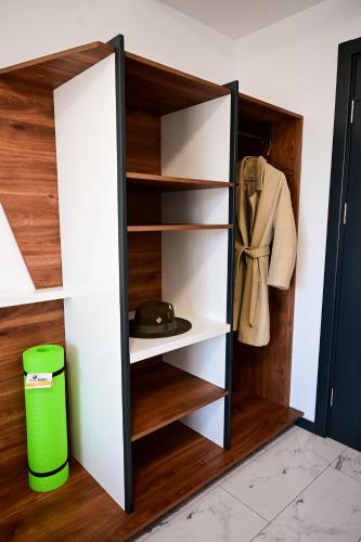 a closet with white shelves and a green trash can at RUBO Hotel in Shumen