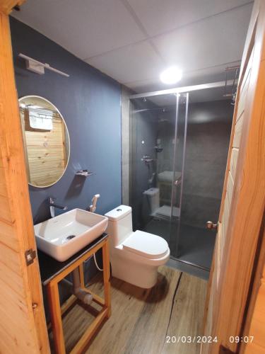 a bathroom with a toilet and a sink and a shower at Kodai Glamp in Kodaikānāl