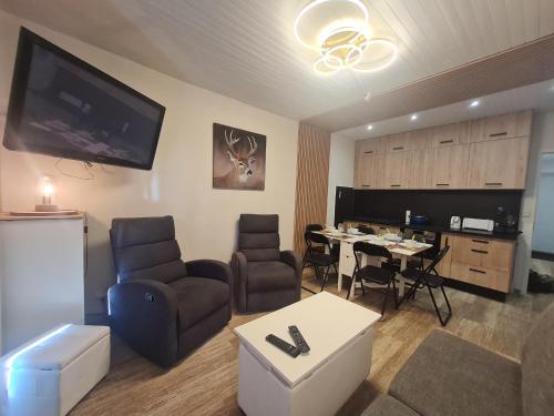 - un salon avec une table, des chaises et une télévision dans l'établissement Lauvitel - J6 - Appt pres des pistes 6 pers, à Les Deux Alpes