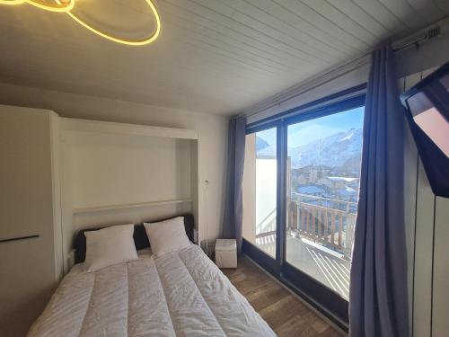 une chambre avec un lit et une grande fenêtre dans l'établissement Lauvitel - J6 - Appt pres des pistes 6 pers, à Les Deux Alpes