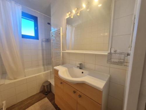 une salle de bain blanche avec un lavabo et un miroir dans l'établissement Lauvitel - J6 - Appt pres des pistes 6 pers, à Les Deux Alpes