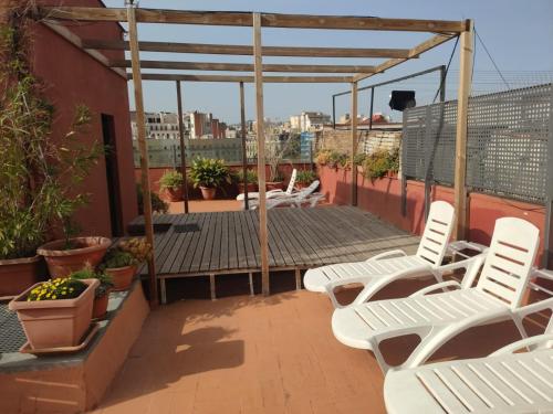 a group of white chairs sitting on a roof at Diagonal Apartments in Barcelona