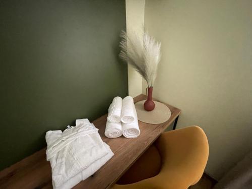 a wooden table with towels and a vase on it at RELAX апартаменти - гр.ДИМИТРОВГРАД in Dimitrovgrad