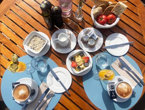 a table with plates of food and a bowl of fruit at Sa Nau Agroturismo - Adults Only over 16 in Portocolom