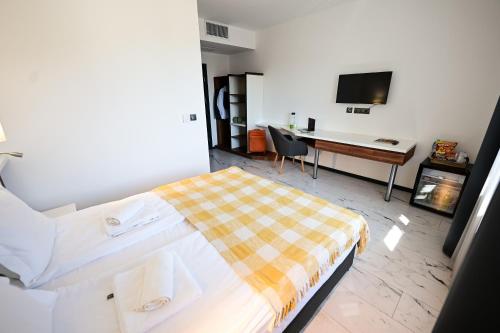 a bedroom with a bed and a desk with a computer at RUBO Hotel in Shumen
