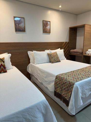 a hotel room with two beds and a chair at HOTEL TERRA NATIVA in Alter do Chao