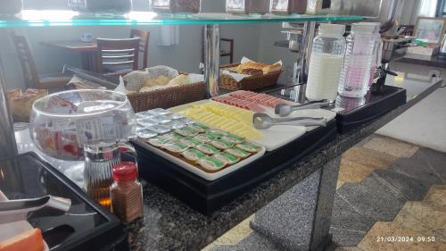 a counter with a tray of different types of food at Hotel Imperador in Santos