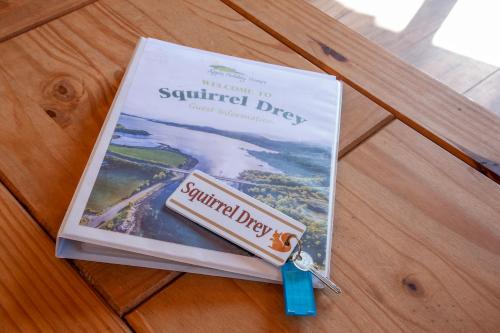 a book sitting on a table with a pair of keys at Appin Holiday Homes -Caravans, Lodges, Shepherds Hut and Train Carriage stays in Appin