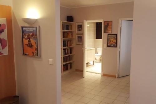 un salon avec un couloir et une étagère à livres dans l'établissement Casa Charlotte nel cuore di Cannes, à Cannes