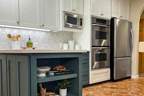 a kitchen with a blue island in a kitchen with a refrigerator at Peaceful Retreat on Quiet Cove on Lake Travis in Lakeway