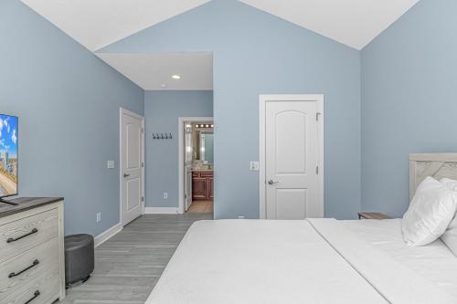a bedroom with blue walls and a white bed at Spacious 4 Bedroom House-2 Blocks From the Ocean-2185 Sanibel Court! in Myrtle Beach
