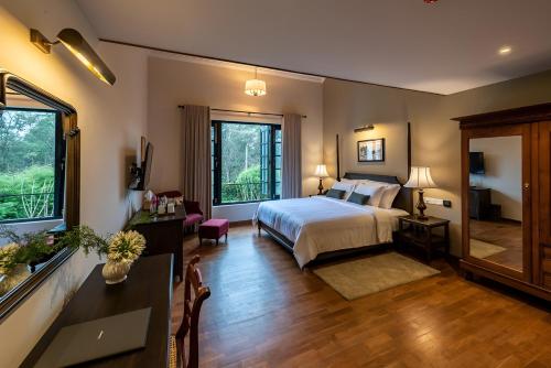 a bedroom with a bed and a living room at Chimneys Nuwara Eliya in Nuwara Eliya