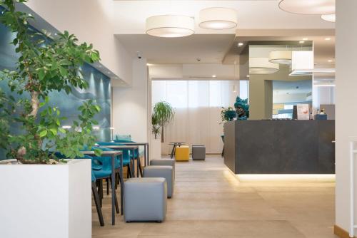 an office lobby with blue tables and chairs at Albatros Beach Hotel in Letojanni