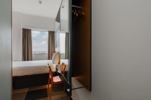 a bedroom with a bed and a mirror at easyHotel Amsterdam Zaandam in Zaandam