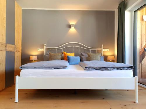 a white bed with pillows on it in a room at Ferienhaus Berger mit eigenen Whirlpool im Garten in Garmisch-Partenkirchen