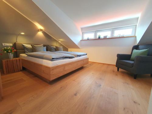 a bedroom with a bed and a window and a chair at Ferienhaus Berger mit eigenen Whirlpool im Garten in Garmisch-Partenkirchen