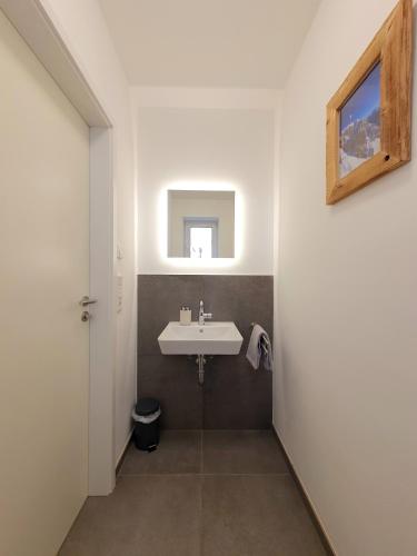 a bathroom with a white sink and a window at Ferienhaus Berger mit eigenen Whirlpool im Garten in Garmisch-Partenkirchen