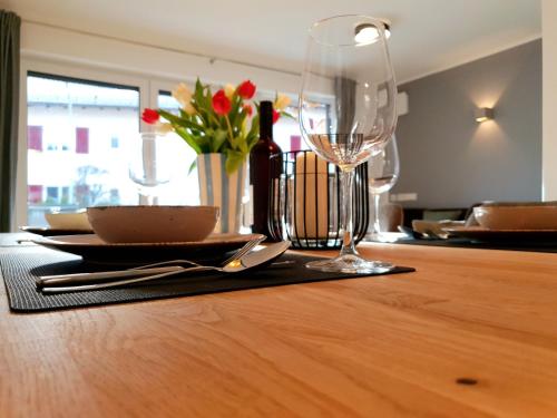 a wooden table with a plate and a wine glass at Ferienhaus Berger mit eigenen Whirlpool im Garten in Garmisch-Partenkirchen