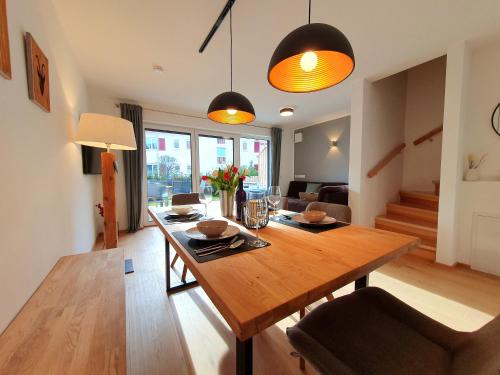 a dining room with a wooden table and a living room at Ferienhaus Berger mit eigenen Whirlpool im Garten in Garmisch-Partenkirchen