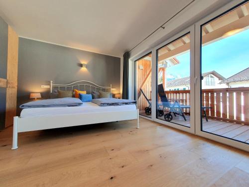 a bedroom with a bed and a balcony at Ferienhaus Berger mit eigenen Whirlpool im Garten in Garmisch-Partenkirchen
