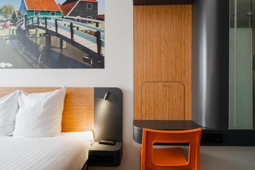 a bedroom with a bed and a desk with a chair at easyHotel Amsterdam Zaandam in Zaandam