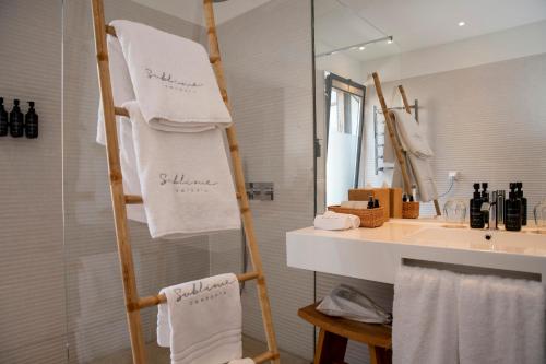 a towel rack with towels on it in a bathroom at Sublime Comporta Country Retreat & SPA in Comporta
