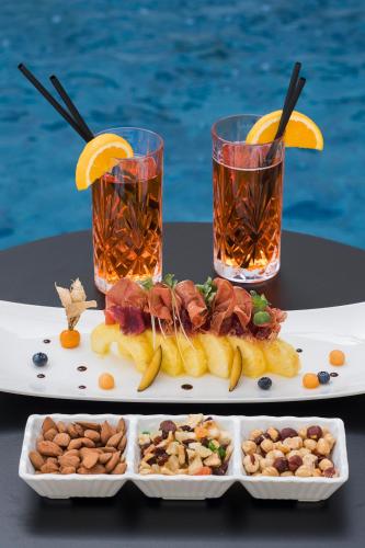 a table with two plates of food and two drinks at Albatros Beach Hotel in Letojanni