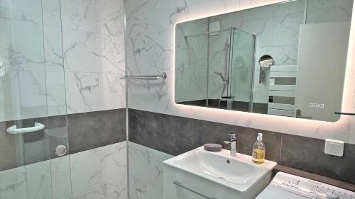 une salle de bain avec un lavabo et un miroir dans l'établissement Silène, à Sainte-Maxime