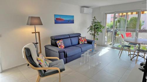 un salon avec un canapé bleu et une table dans l'établissement Silène, à Sainte-Maxime