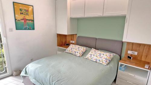 une chambre avec un lit avec deux oreillers dessus dans l'établissement Silène, à Sainte-Maxime