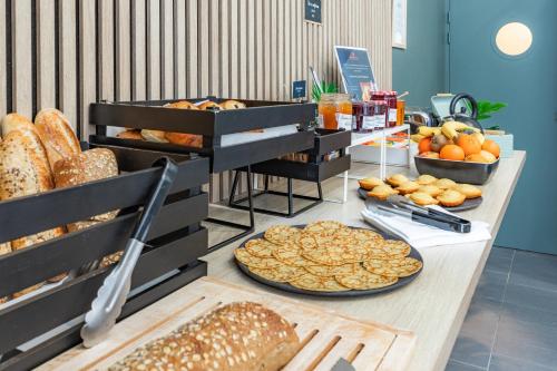 una mesa con varios tipos de pan y otros alimentos en Appart'City Classic Marseille Euromed, en Marsella