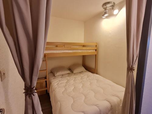 - une petite chambre avec des lits superposés et un rideau dans l'établissement Meijotel - 208 - Studio renove - 4 pers, à Les Deux Alpes