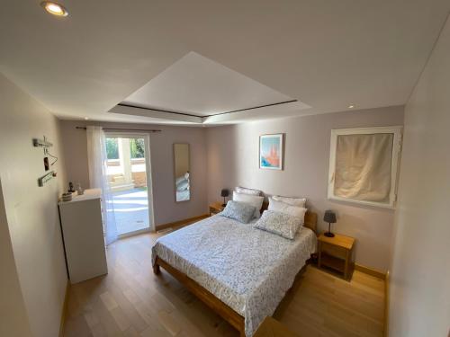 ein Schlafzimmer mit einem Bett mit Kissen und einem Fenster in der Unterkunft Grande Villa contemporaine à Grignan in Grignan