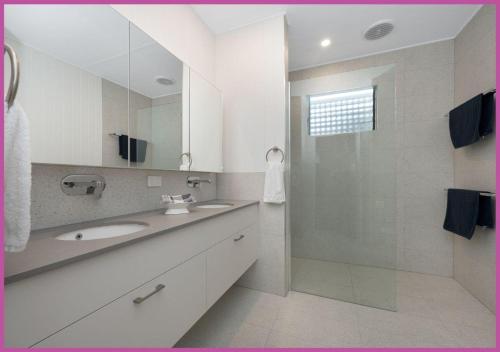 y baño blanco con lavabo y ducha. en The Ultimate Queensland Holiday!, en Aitkenvale