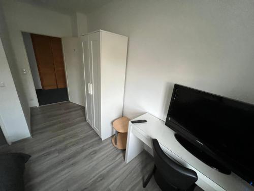 a room with a television and a desk with a chair at Upper-House Goldener Hirsch in Aystetten
