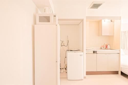 Mi-APT SHIRO في طوكيو: ثلاجة بيضاء في مطبخ مزود بميكروويف