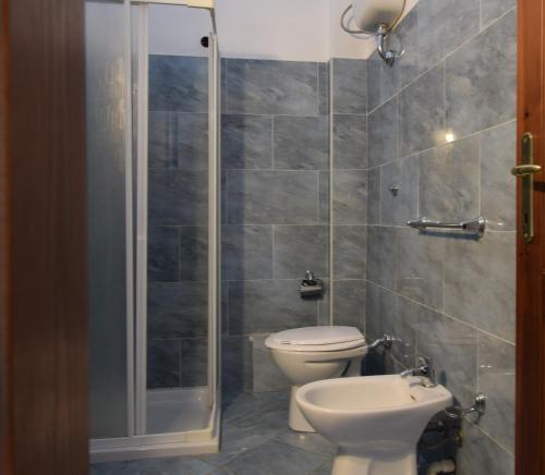 uma casa de banho com um WC e uma cabina de duche em vidro. em Appartamento Comino Sole Sea View em Siniscola