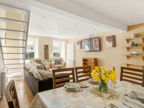 a dining room with a table and a living room at King's Apartment in Clifden