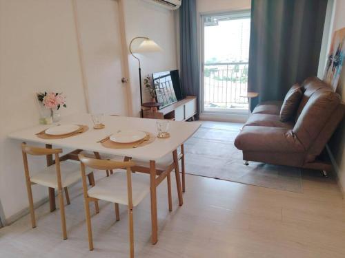 a living room with a table and a couch at 2BR, 6 Mins walk BTS Wuttakat in Bangkok