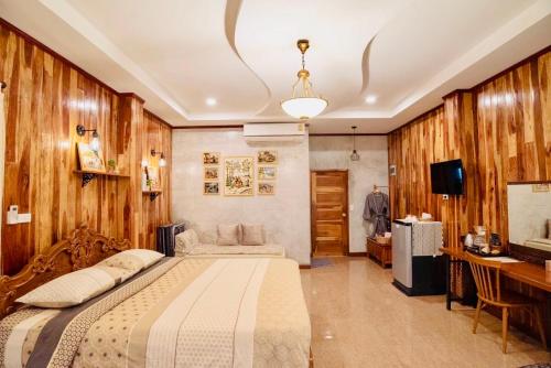 um quarto com uma cama, uma secretária e uma televisão em ชนบท เขาใหญ่ em Ban Tha Chang