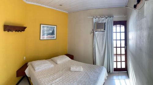 a bedroom with a bed and a window at Suites Ponta Leste in Angra dos Reis